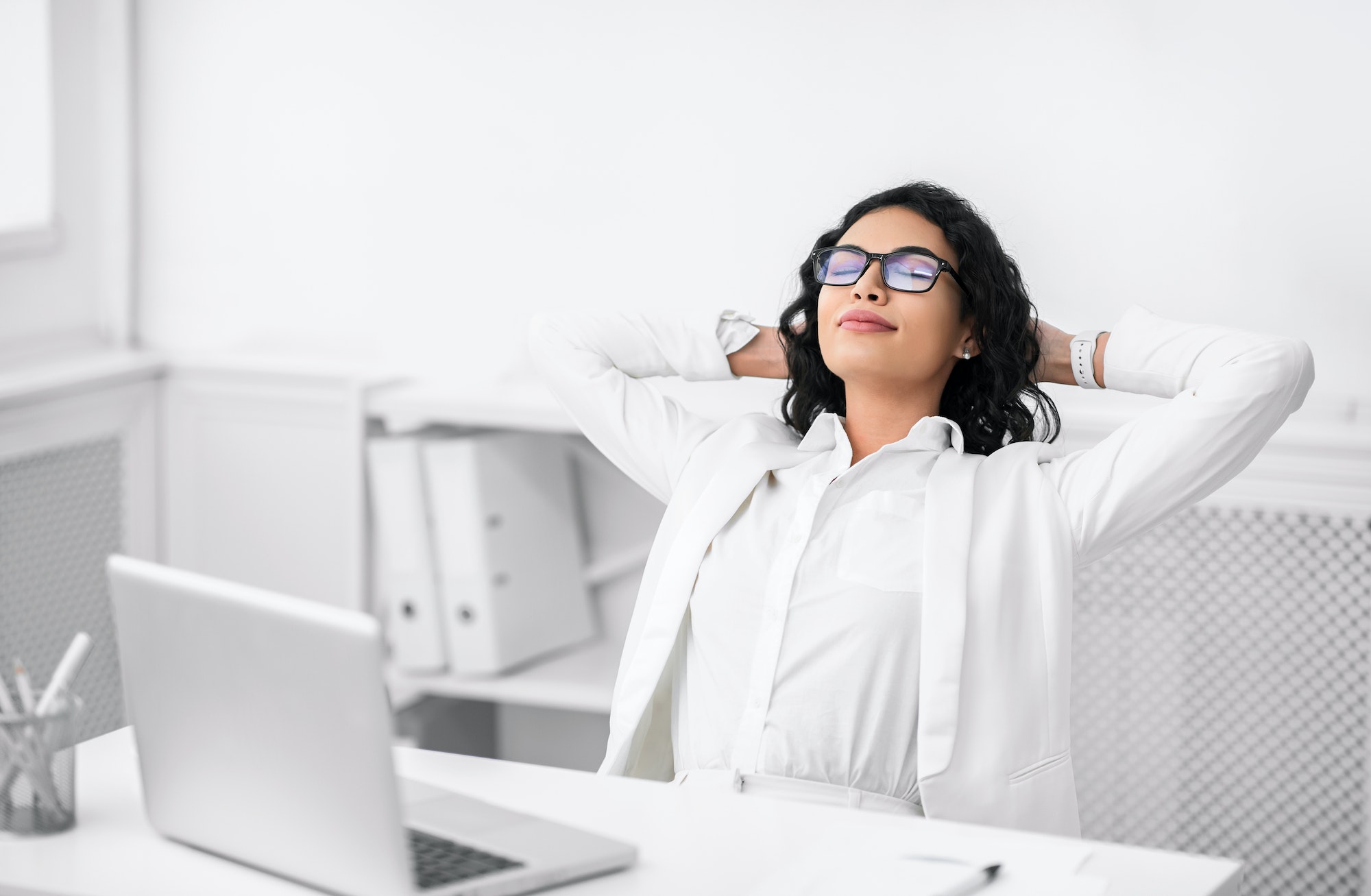 Hispanic businesswoman in glasses relaxing at work